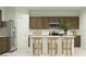 Stylish kitchen featuring stainless steel appliances, an island with barstool seating, and wooden cabinetry at 5064 S 234Th Ave, Buckeye, AZ 85326
