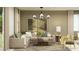 Comfortable living room featuring a neutral sectional sofa, modern light fixture, and stylish decor at 5064 S 234Th Ave, Buckeye, AZ 85326
