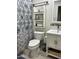 Bathroom featuring a modern sink, toilet, decorative shelves, and shower with patterned curtain at 5303 W Port Au Prince Ln, Glendale, AZ 85306