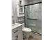 Modern bathroom featuring a tiled shower, toilet, vanity and wall storage at 5303 W Port Au Prince Ln, Glendale, AZ 85306