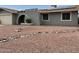 Charming home featuring a unique architectural front with decorative rock landscaping and solar panels at 5303 W Port Au Prince Ln, Glendale, AZ 85306