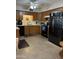 Well-lit kitchen featuring black appliances, wooden cabinetry, and sleek countertops at 5303 W Port Au Prince Ln, Glendale, AZ 85306