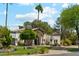 A beautiful single-story home featuring lush landscaping, a stone chimney, and an arched entry for welcoming curb appeal at 5402 E Cortez Dr, Scottsdale, AZ 85254