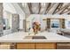 Stylish kitchen island sink with wood cutting board insert, faucet, and adjacent living space with stone pillar at 5402 E Cortez Dr, Scottsdale, AZ 85254