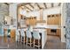 Stunning kitchen featuring a large waterfall island, modern cabinetry, and industrial-style exposed beam ceilings at 5402 E Cortez Dr, Scottsdale, AZ 85254