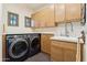 Spacious laundry room featuring a front-load washer and dryer, wood cabinets, and ample counter space at 5402 E Cortez Dr, Scottsdale, AZ 85254