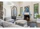 Cozy living room featuring a stone fireplace, iron doors, and comfortable seating provides an inviting gathering space at 5402 E Cortez Dr, Scottsdale, AZ 85254