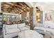 Spacious living area with stone pillars, exposed beams, comfortable seating, and a view of the outdoor living space at 5402 E Cortez Dr, Scottsdale, AZ 85254
