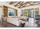 Bright living room features a soaring ceiling with exposed wood beams, built-in shelving, and polished concrete floors at 5402 E Cortez Dr, Scottsdale, AZ 85254
