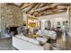 Expansive living area with stone fireplace, exposed wood beams, comfortable seating, and open floor plan at 5402 E Cortez Dr, Scottsdale, AZ 85254