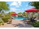 Luxury pool featuring a rock waterfall, mature palm trees, and patio seating for outdoor enjoyment at 5402 E Cortez Dr, Scottsdale, AZ 85254
