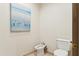 Clean powder room with bidet, toilet, and beach-themed artwork at 5402 E Cortez Dr, Scottsdale, AZ 85254