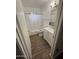 Cozy bathroom with a white vanity, a bathtub with shower, and wood look flooring at 5517 E Boise St, Mesa, AZ 85205