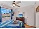 Bedroom features a ceiling fan, wood flooring, and beach themed bedding with a television on a dark wood stand at 560 W Duke Dr, Tempe, AZ 85283