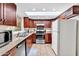 Efficient kitchen featuring cherry wood cabinets, stainless steel appliances, and ample natural light from a skylight at 560 W Duke Dr, Tempe, AZ 85283