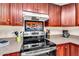 Stylish kitchen with stainless steel oven, decorative tile backsplash and warm cherry wood cabinetry at 560 W Duke Dr, Tempe, AZ 85283