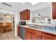 Functional kitchen with cherry cabinets, stainless appliances, and view to the living and dining areas at 560 W Duke Dr, Tempe, AZ 85283