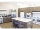 A commercial style kitchen with white appliances, large island with seating, and modern fixtures at 5735 E Mcdowell Rd # 63, Mesa, AZ 85215