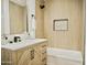 Bathroom with light wood vanity, bathtub, shower head, backsplash and marble countertop at 6401 E Eugie Ter, Scottsdale, AZ 85254
