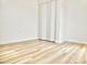 Bedroom featuring wood-look floors, white trim and white folding doors at 6401 E Eugie Ter, Scottsdale, AZ 85254