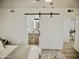Bedroom with barn door access to bathroom and views into the adjacent living room at 6401 E Eugie Ter, Scottsdale, AZ 85254