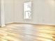 Bright bedroom featuring wood-look flooring, white walls, and a window view of a palm tree at 6401 E Eugie Ter, Scottsdale, AZ 85254