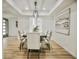 Elegant dining room with a modern chandelier, wood floors, and comfortable upholstered chairs at 6401 E Eugie Ter, Scottsdale, AZ 85254