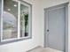 Exterior detail featuring a window, tree and gray door, showcasing modern design at 6401 E Eugie Ter, Scottsdale, AZ 85254