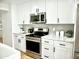 Updated kitchen with white cabinets, quartz countertops, and stainless steel appliances at 6401 E Eugie Ter, Scottsdale, AZ 85254