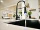 Modern kitchen sink featuring a black faucet and stylish countertops, with elegant glassware on display at 6401 E Eugie Ter, Scottsdale, AZ 85254