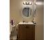Bathroom with wood-stained vanity, framed round mirror and standard plumbing at 8307 W Indianola Ave, Phoenix, AZ 85037