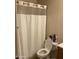 Standard bathroom with a toilet, shower curtain, and essential toiletries, designed for convenience at 8307 W Indianola Ave, Phoenix, AZ 85037