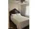Cozy bedroom with a dark wood headboard and ceiling fan, providing a relaxing retreat at 8307 W Indianola Ave, Phoenix, AZ 85037