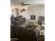 Comfortable living room features a brick fireplace, ceiling fan, neutral paint and tile floors at 8307 W Indianola Ave, Phoenix, AZ 85037