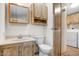 Well-lit bathroom with a vanity, toilet, and access to a laundry area, offering convenience and functionality at 853 S Evangeline Ave, Mesa, AZ 85208