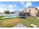 Large backyard with pool, trampoline, grassy area, patio, and block wall at 8912 W Sheridan St, Phoenix, AZ 85037