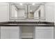 Bathroom vanity with dual sinks, illuminated mirrors, and white cabinets in a well-lit space at 8912 W Sheridan St, Phoenix, AZ 85037