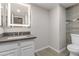 Stylish bathroom featuring a floating vanity with a modern lit mirror, sleek fixtures, and contemporary gray tile flooring at 8912 W Sheridan St, Phoenix, AZ 85037