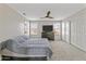 Spacious bedroom featuring carpeted floors, a ceiling fan, a large TV, and plenty of closet space at 8912 W Sheridan St, Phoenix, AZ 85037