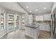 Bright kitchen with white cabinetry, an island, stainless steel appliances, and a door to the backyard deck at 8912 W Sheridan St, Phoenix, AZ 85037