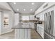 Bright kitchen featuring white cabinets, stainless steel appliances, stone countertops and a center island at 8912 W Sheridan St, Phoenix, AZ 85037