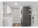 Laundry room with stackable washer/dryer, white cabinets and folding counter at 8912 W Sheridan St, Phoenix, AZ 85037