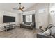 Living area features a ceiling fan, large screen tv, sofa, and a cozy seating arrangement at 8912 W Sheridan St, Phoenix, AZ 85037