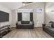 Bright living room with gray sofas, wood-look floors, large windows, and a glass panel front door at 8912 W Sheridan St, Phoenix, AZ 85037