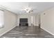 Living room with wood-look floors, ceiling fan and large screen TV with dark media cabinet at 8912 W Sheridan St, Phoenix, AZ 85037