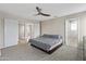 This bedroom is spacious and features plush carpet, ceiling fan, and double doors to another room at 8912 W Sheridan St, Phoenix, AZ 85037
