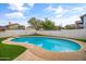 Inviting backyard pool with stone coping and artificial grass surround at 8912 W Sheridan St, Phoenix, AZ 85037