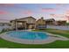 Backyard features a sparkling blue pool, diving board, and an artificial turf lawn that extends to the covered patio at 8912 W Sheridan St, Phoenix, AZ 85037