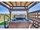 Backyard hot tub with overhead wood pergola with lights for relaxing evenings at 11249 N Blakely St, Surprise, AZ 85388