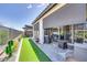 This is a covered patio with furniture, outdoor grill, and green grass in the backyard at 11249 N Blakely St, Surprise, AZ 85388